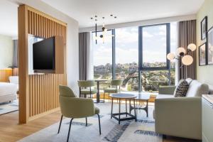 a living room with a couch and a table and chairs at Sheraton Uşak Hotel & Thermal Spa in Uşak