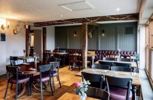 ein Restaurant mit Holztischen und lila Stühlen in der Unterkunft The Fox and Maple in Wickwar