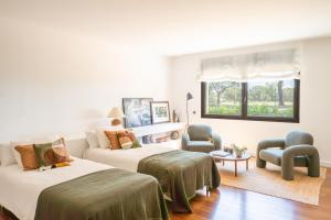 a bedroom with two beds and a couch and a window at Majordoms Golf Peralada in Peralada +55 photos