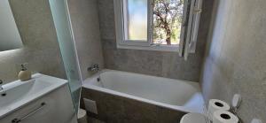a bathroom with a white tub and a sink at chez Henri-Ange in Saint-Raphaël