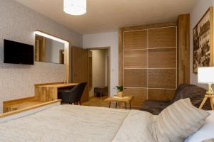 a bedroom with a bed and a desk with a chair at Wellness Hotel Gendorf in Vrchlabí