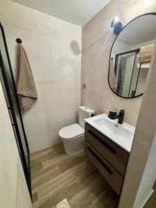 a bathroom with a toilet and a sink and a mirror at SOLyMAR in Garrucha