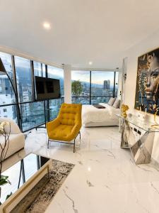 a living room with a yellow chair and a bed at NIDO Boutique Hotel in Quito