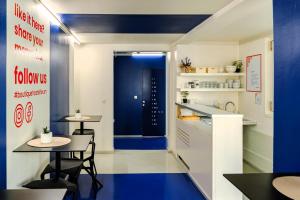 a kitchen with two tables and a blue door at Boutique Hostel Forum in Zadar