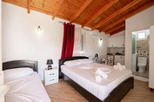two twin beds in a room with a kitchen at Nino's rooms in Ksamil