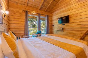 a bedroom with a bed in a room with wooden walls at Echor Malusara Lakeview Retreat Bhimtal in Bhīm Tāl