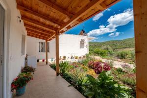 an external view of a house with a wooden pergola at Nino's rooms in Ksamil