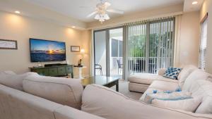 a living room with white furniture and a flat screen tv at 612 Mariners Club in Key Largo