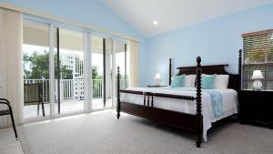 a bedroom with a bed and a balcony with sliding glass doors at 612 Mariners Club in Key Largo +47 photos