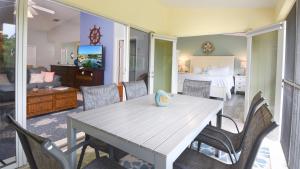 a dining room with a table and chairs and a bedroom at 802 Mariners Club in Key Largo