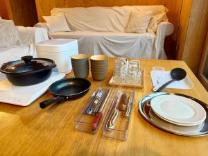 a wooden table with plates and utensils on it at anandahの宿 in Miyazaki