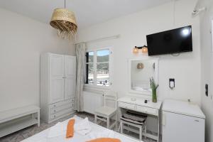 a kitchen with a desk and a tv on the wall at Albatros in Skopelos Town