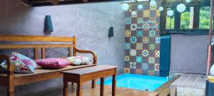 a room with a bed and a bench with pillows at Espaço Vintage Hospedaria Suíte Alento in Prados