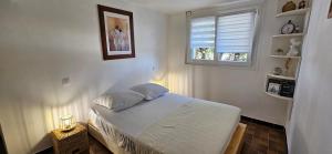 a small bedroom with a bed and a window at chez Henri-Ange in Saint-Raphaël