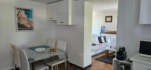 a kitchen and living room with a table and a couch at chez Henri-Ange in Saint-Raphaël