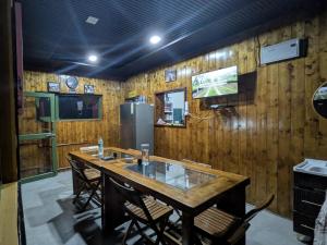 eine Küche mit Tisch, Stühlen und Kühlschrank in der Unterkunft Lal Bangla Homestay in Chaukori