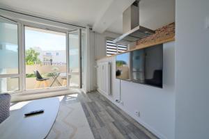 a living room with a large window and a tv at Le petit nid Rémois - Parking - King size in Reims