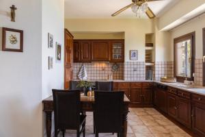 a kitchen with wooden cabinets and a table with chairs at Thalia- 2 Bedroom Beachfront Apartment! in Lefokastro