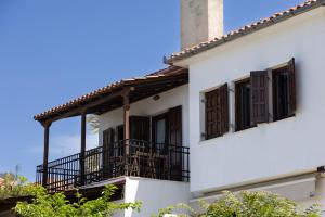 a white building with windows and a balcony at Thalia- 2 Bedroom Beachfront Apartment! in Lefokastro