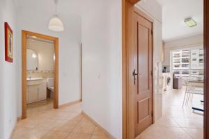 a hallway with a door leading to a kitchen at Rei Apartment in Quarteira +136 photos