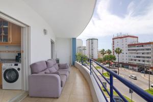 a living room with a couch on a balcony at Rei Apartment in Quarteira