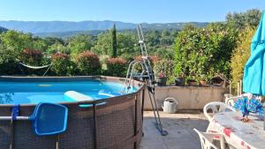 a hot tub on a patio with a table and a view at Chez Mich'An Luberon in Saignon
