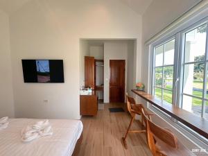 a room with a bed and a desk and a window at Stayokay Sattahip ที่พักสัตหีบ in Sattahip
