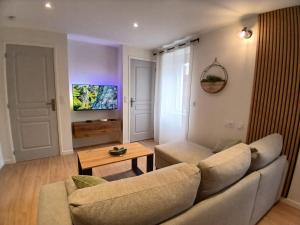 a living room with a couch and a table at La maisonnette in Saint-Georges-de-Luzençon