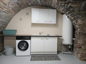 a kitchen with a sink and a washing machine at La maisonnette in Saint-Georges-de-Luzençon