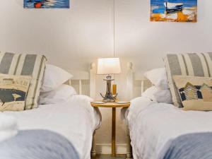 a room with two beds and a table with a lamp at 2 Bed in Brixham oc-bx021 in Brixham