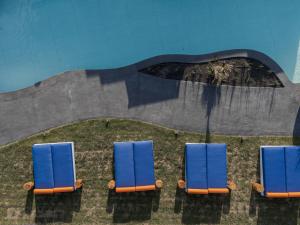 two blue chairs in front of a swimming pool at Cresanto Luxury Suites in Imerovigli +55 photos