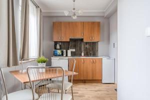 a kitchen with wooden cabinets and a table and chairs at Apartamenty Zefir in Rowy