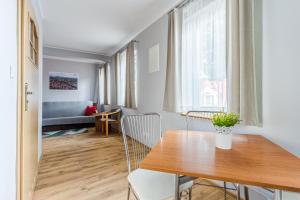 a dining room and living room with a table and chairs at Apartamenty Zefir in Rowy