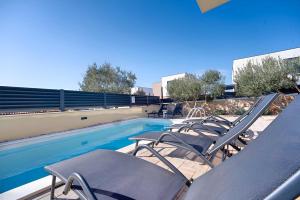 a group of chairs sitting next to a swimming pool at Timm - Luxury Villas in Vodice