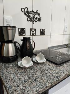 a kitchen counter with two plates and a coffee maker at Próximo a UFV 950m, prédio muito tranquilo in Viçosa