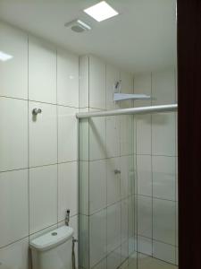 a bathroom with a toilet and a glass shower at Próximo a UFV 950m, prédio muito tranquilo in Viçosa