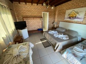 a room with two beds and a flat screen tv at HervaDoce in Rio das Ostras