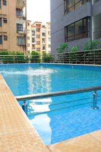 a large blue swimming pool with buildings in the background at Malkia Exquisite Homes in Nairobi