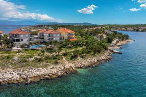 an aerial view of a house on an island in the water at Villas Punta Silo - luxury apartments with pool in Šilo