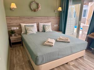 a bedroom with a bed with two towels on it at AVLI Sarti Studios & Apartments no2 in Sarti +7 photos