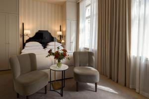 a hotel room with a bed and two chairs and a table at Villa Dagmar in Stockholm