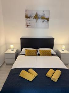 a bedroom with a large bed with two yellow pillows at Apartments Lory in Rabac