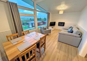 a living room with a table and a couch at Elmrise View in Llanstephan
