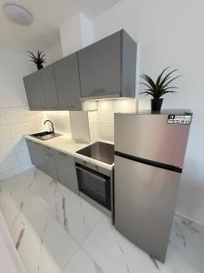 a kitchen with white cabinets and a stainless steel refrigerator at Apartments Lory in Rabac