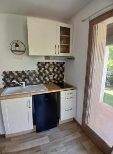 a small kitchen with a sink and a counter at Chambre d'hôte Amouratcha in Fabrègues