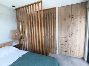 a bedroom with a bed and wooden cabinets at my suite home in Heraklio