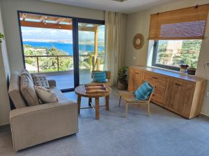 a living room with a couch and a table and a window at my suite home in Heraklio