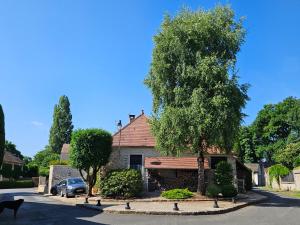 a house with a tree and birds in front of it at La forge in Torfou