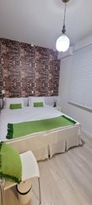 a bedroom with a large bed with green cushions at Pousada Buona Serata in Bento Gonçalves