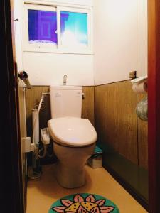 a bathroom with a toilet with a window and a rug at MEGANE HOUSE First floor All private in Rankoshi +13 photos